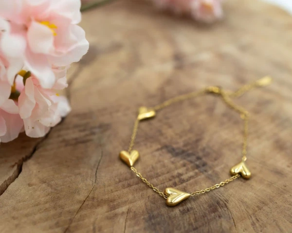 Gouden armband met vier hartjes bedels