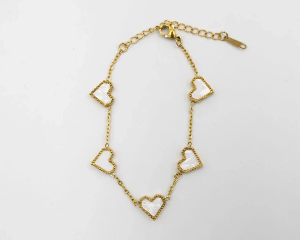 Gouden armband met witte hartjes
